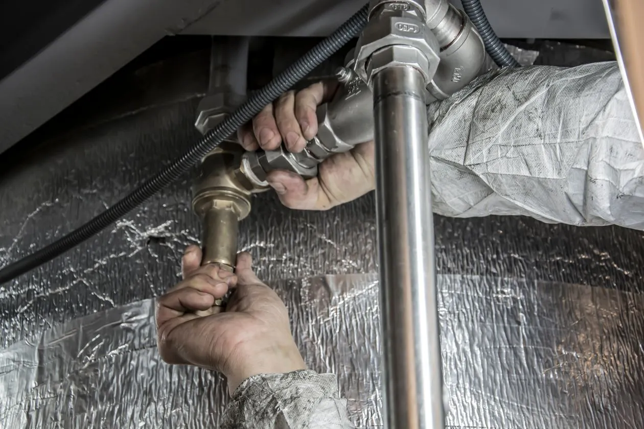 Professional plumber performing drain cleaning at a Fort Worth home